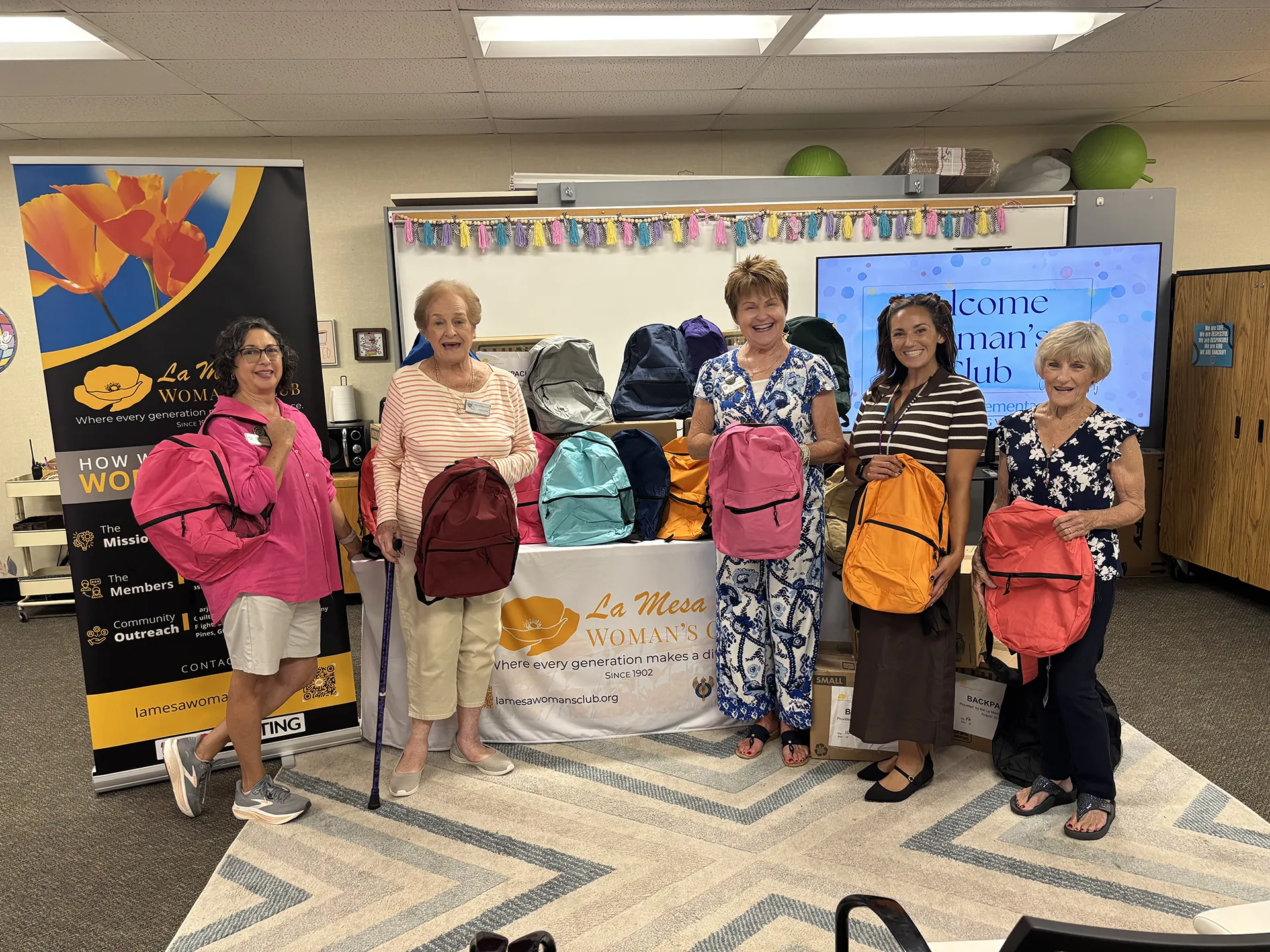 La Mesa Woman's Club members pose with donated backpacks during the Bancroft Elementary Back-to-School Backpack Presentation.