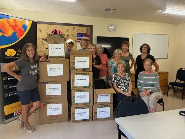Volunteers with backpacks donated for Bancroft Elementary students